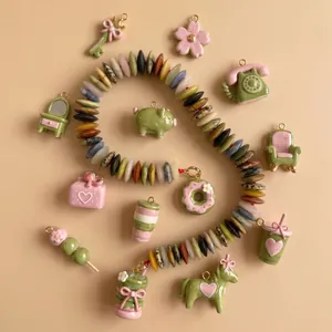 Vue détaillée de breloques en émail rose et vert macaron pour la création de bijoux DIY