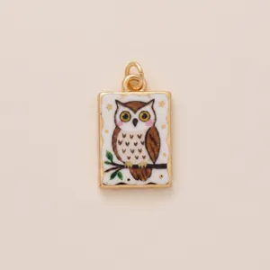 Macro view of a charming vintage hand-painted owl pendant charm in gold-tone finish