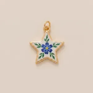 Detailed macro shot of a vintage gold star pendant featuring a painted blue flower