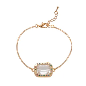 Close-up of gold chain bracelet with a transparent rectangular frame and rainbow stones