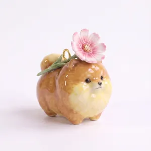 Detailed view of a cute ceramic Pomeranian dog charm featuring a pink flower for DIY jewelry