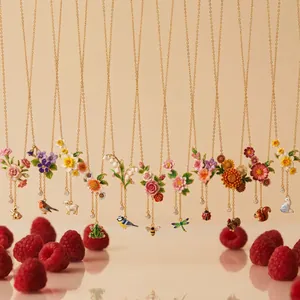 Collezione di collane vintage in smalto con fiori, animali e nappe su catene dorate