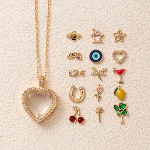 Dettaglio di una collana medaglione a cuore in oro con vari ciondoli smaltati