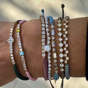 Nahaufnahme von mehrfarbigen geflochtenen verstellbaren Armbändern mit Zirkonia-Anhängern