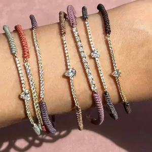 Detail von gestapelten bunten geflochtenen Armbändern mit Zirkonia-Anhängern.