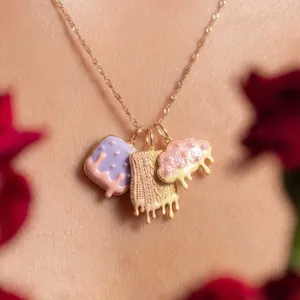 Primo piano di una collana con ciondoli in smalto pastello, design a goccia e trama a maglia