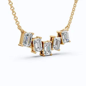 Close-up view of gold-plated smile necklace with five radiant emerald-cut stones.