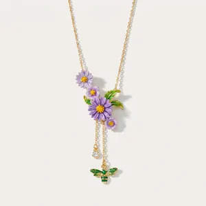 Dettaglio della collana vintage in smalto con fiori viola e ape su catena dorata