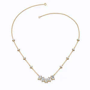 Detail view of a gold necklace with emerald and round cut cubic zirconia stones.
