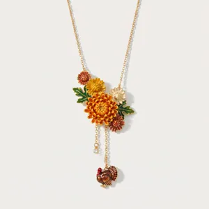 Primo piano di una collana floreale smaltata con ciondolo a nappa di tacchino