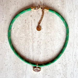 Close-up of retro green woven choker with marquise-cut zircon pendant and gold-tone chain