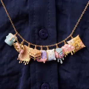 Dettaglio collana a catena dorata con ciondoli smaltati colorati e perle