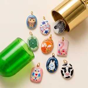 Detailed view of exquisite hand-painted enamel animal pendants with owl and fox motifs