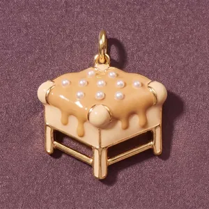 Primo piano di un ciondolo creativo a forma di mobile con perle e smalto colato.