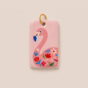 Detailed view of a hand-painted pink flamingo enamel pendant with delicate floral patterns