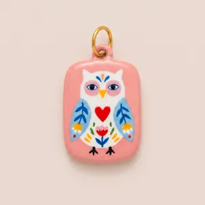 Close-up view of a hand-painted enamel owl pendant charm featuring a red heart detail