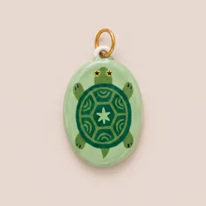 Detail view of a hand-painted enamel turtle pendant with star patterns
