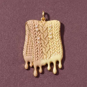 Primo piano di un ciondolo con trama a maglia, perle ed effetto smalto che gocciola