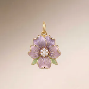 Detailed macro shot of a purple enamel flower pendant with central pearls and gold trim