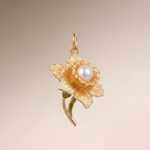 Detail shot of a vintage gold flower pendant with enamel petals and a pearl center