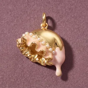 Simpatico ciondolo a forma di medusa in smalto rosa con dettagli in oro e perle.