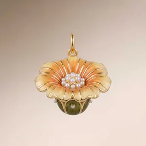 Detailed view of gold flower pendant with orange enamel and pearl cluster center