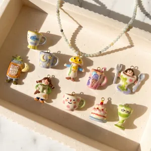 Detailed view of various colorful hand-painted ceramic pendants displayed in a cream tray