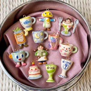 Close-up detail of various hand-painted cartoon ceramic charms for DIY jewelry making