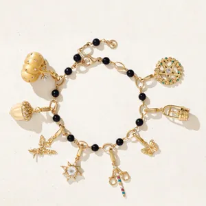 Detail view of vintage charm bracelet with gold-plated pendants and black beads