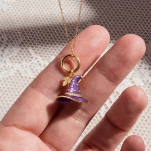 Detailed macro view of a purple enamel witch hat pendant with gold leaf and zircons