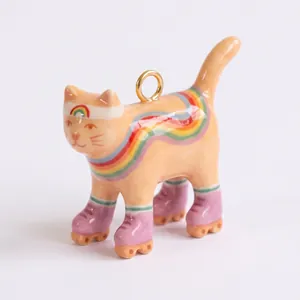 Dettaglio di un ciondolo a forma di gatto dipinto a mano con arcobaleno e pattini