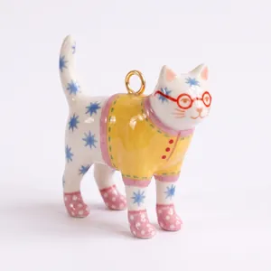 Vista dettagliata di un ciondolo a forma di gatto in ceramica dipinto a mano