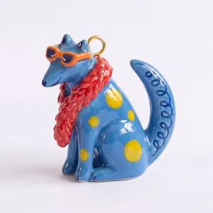 Dettaglio ravvicinato di un ciondolo animale in ceramica blu con sciarpa e occhiali