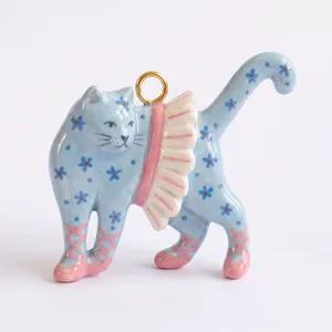 Vista dettagliata del ciondolo a forma di gatto blu dipinto a mano con piccoli fiori
