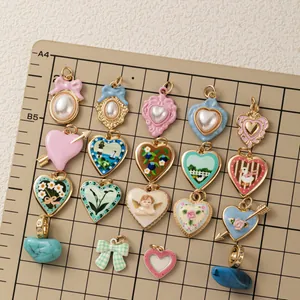 Assortimento di ciondoli a cuore e fiocco con motivi floreali, di angeli e perle