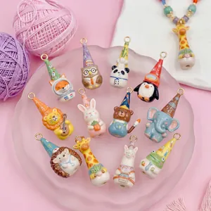 Assorted colorful cartoon animal pendants for DIY jewelry making on a pink background