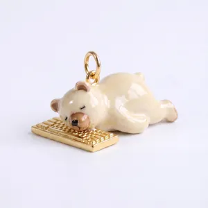 Detailansicht eines niedlichen Emaille-Bären, der auf einem goldenen Tastatur-Anhänger schläft