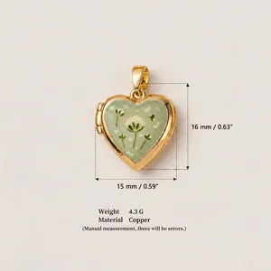 Gros plan d'un médaillon en forme de cœur doré avec motif floral vert et dimensions précises