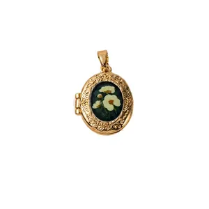 Pendentif médaillon ovale vintage doré avec un motif floral blanc délicat et élégant