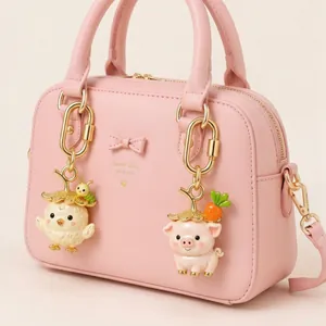 Detail showing cute straw hat chick and pig charms with gold plated hooks on a pink bag