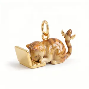 Detaillierte Makroansicht eines 3D-Emaille-Katzenanhängers an einem goldenen Laptop