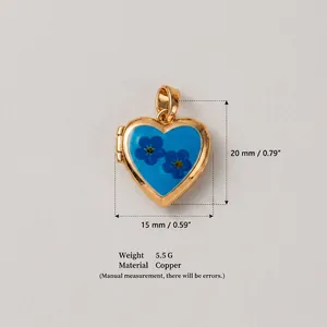 Détails d'un médaillon en forme de cœur en cuivre doré avec incrustation florale bleue