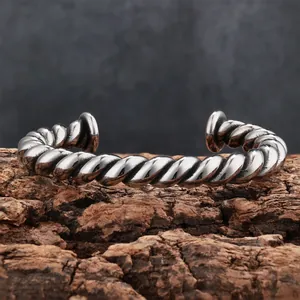 Close-up detail of vintage heavy twisted titanium steel cuff bracelet for men on tree bark
