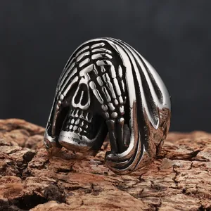 Macro view of a gothic skull ring with vintage distressed finish on natural wood bark.