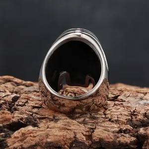 Detailed back view of vintage skull stainless steel wide band ring on bark texture