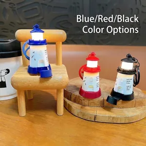 Close-up of glowing lighthouse keychains in three colors on miniature wooden chair.