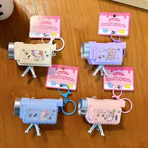 Set of 4 cartoon camera projector keychains in pastel colors with cute animal designs.