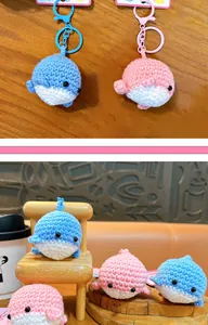 Detailed view of handmade crochet whale keychains in vibrant blue and pink colors.