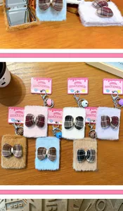 Detailed view of plush bow mirror keychains in various colors with small bell charms