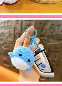 Detailed macro view of a blue hand-knitted crochet whale keychain used as a cute bag charm